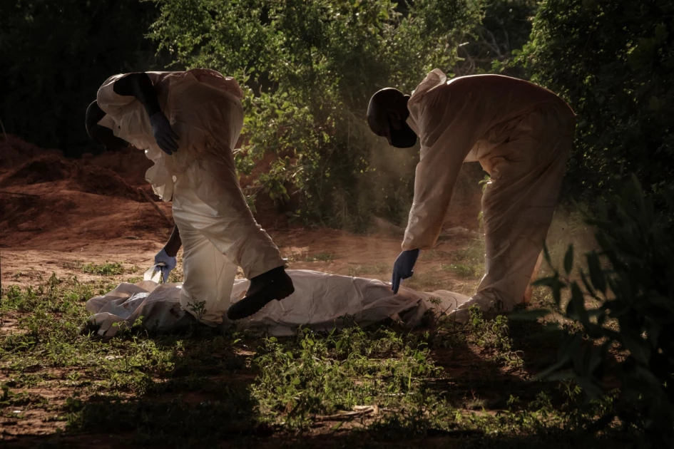 Workers carry a body bag to the mortuary after exhuming bodies at the mass-grave site in Shakahola, Kilifi County on April 25, 2023.
